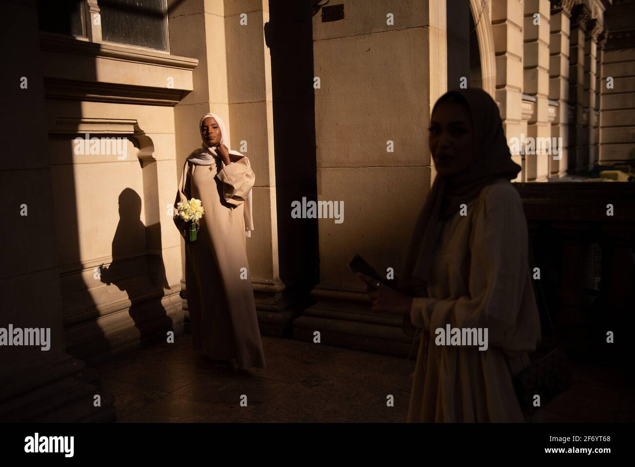 Die Freunde Ikraam Kamal (L) und Farzana Akhtarr fotografieren sich während der späten Nachmittagssonne in Birmingham. Bilddatum: Samstag, 3. April 2021. Stockfoto