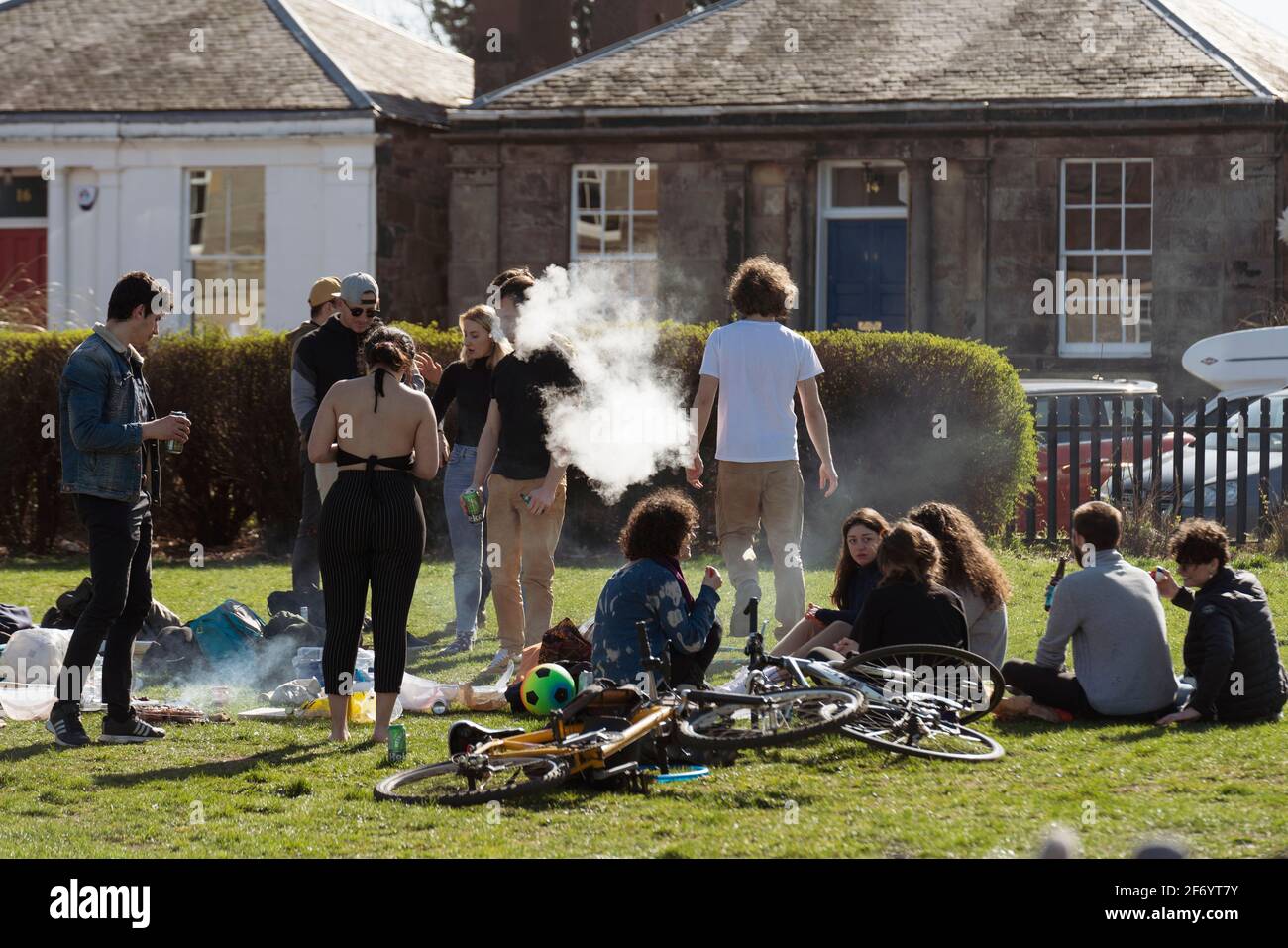 Portobello, Schottland, Großbritannien. 3. April 2021. Am Osterwochenende strömen Massen an den Strand und die Promenade von Portobello, um das Beste aus den neu entspannten Reisebeschränkungen von Covid-19 und der warmen Sonne mit ununterbrochenem blauen Himmel zu machen. PIC; Gruppe von jungen Leuten mit Grill und Getränken auf der Promenade. Iain Masterton/Alamy Live News Stockfoto