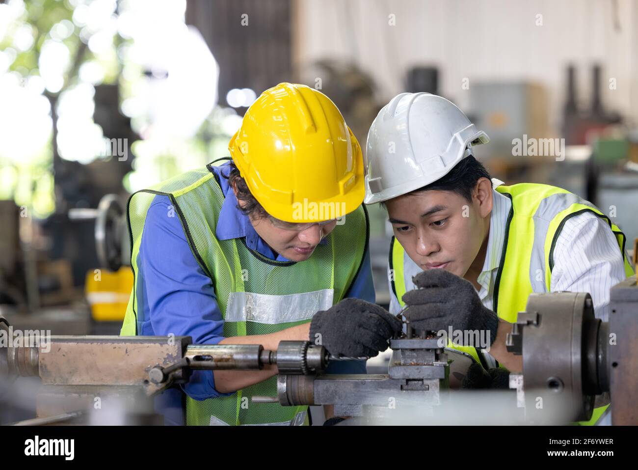 Zwei Arbeiter im Produktionswerk als Team diskutieren, Industrieszene im Hintergrund, arbeiten zusammen Fertigungstätigkeiten Stockfoto