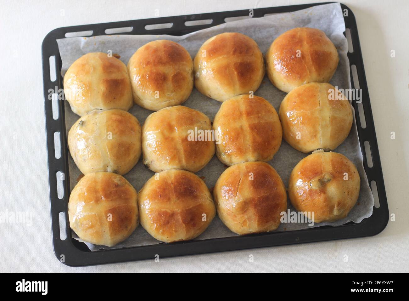 Frisch gebackene heiße Brötchen. Am Karfreitag wird ein süßes Fruchtbrötchen serviert, das leicht mit Zimt und Muskat gewürzt und mit einem Kreuz auf der Oberseite gekennzeichnet ist. A tra Stockfoto