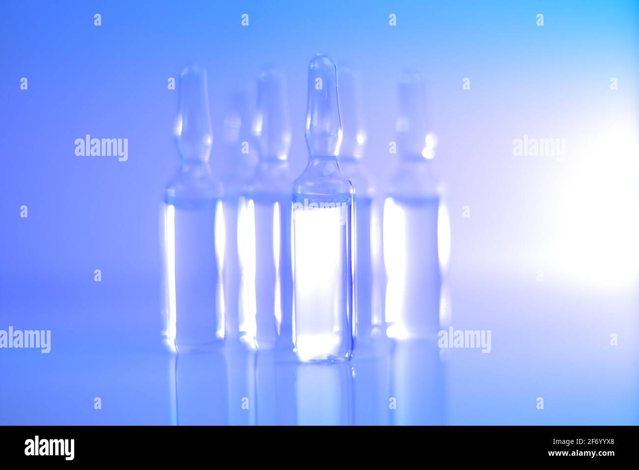 Medizin und Pharmakologie.Biotechnologie und Wissenschaft. Transparente Ampullen in hellblauen und violetten Tönen gesetzt.Ampullen mit Injektionslösung Stockfoto
