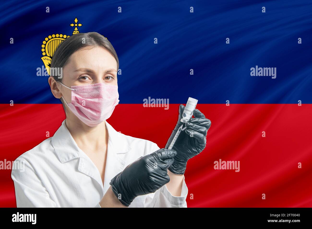 Ärztin bereitet die Impfung vor dem Hintergrund der Liechtensteiner Flagge vor. Impfkonzept Liechtenstein. Stockfoto