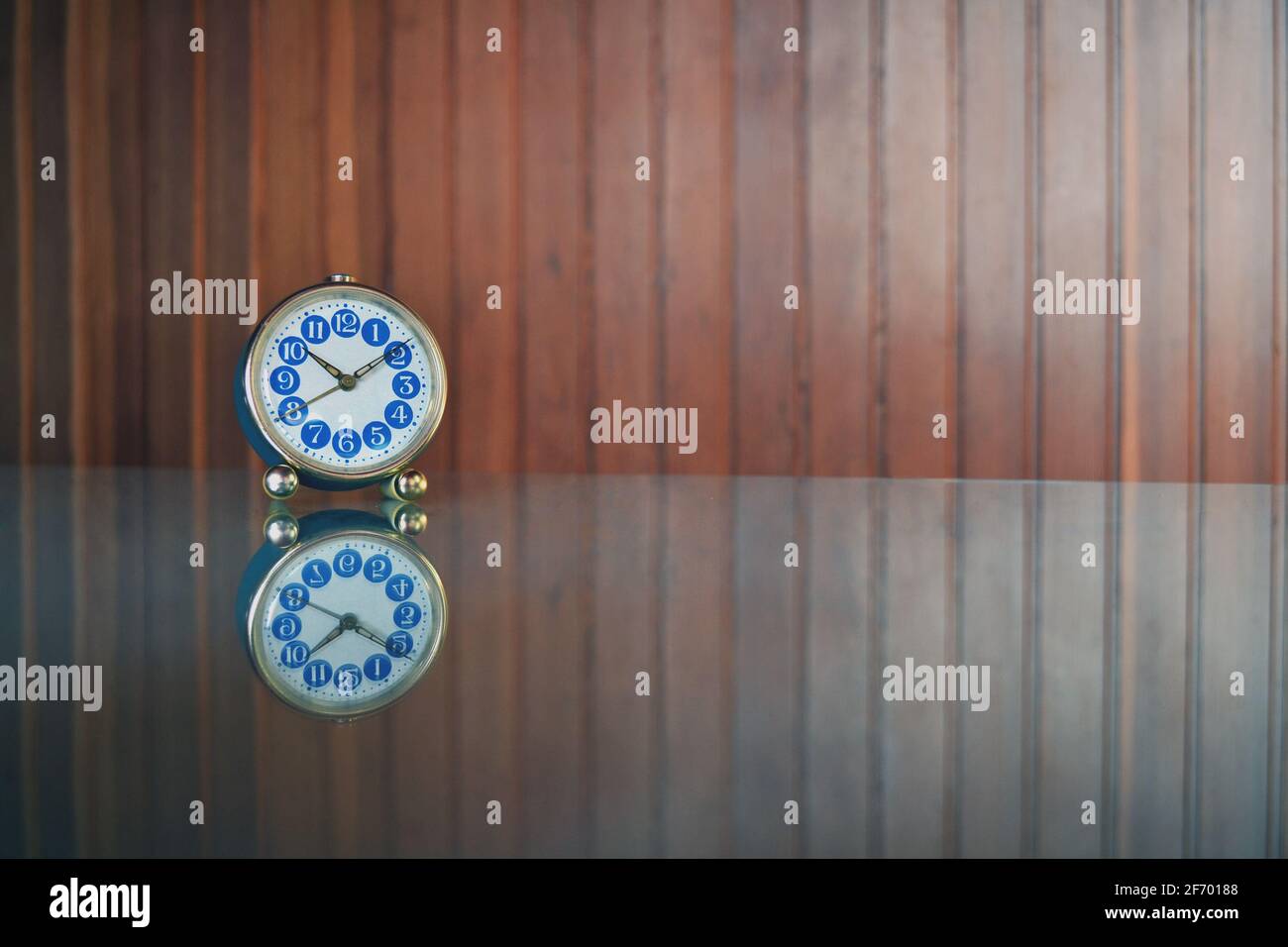 Kleine, blaue Tischuhr mit Spiegelung. Stockfoto