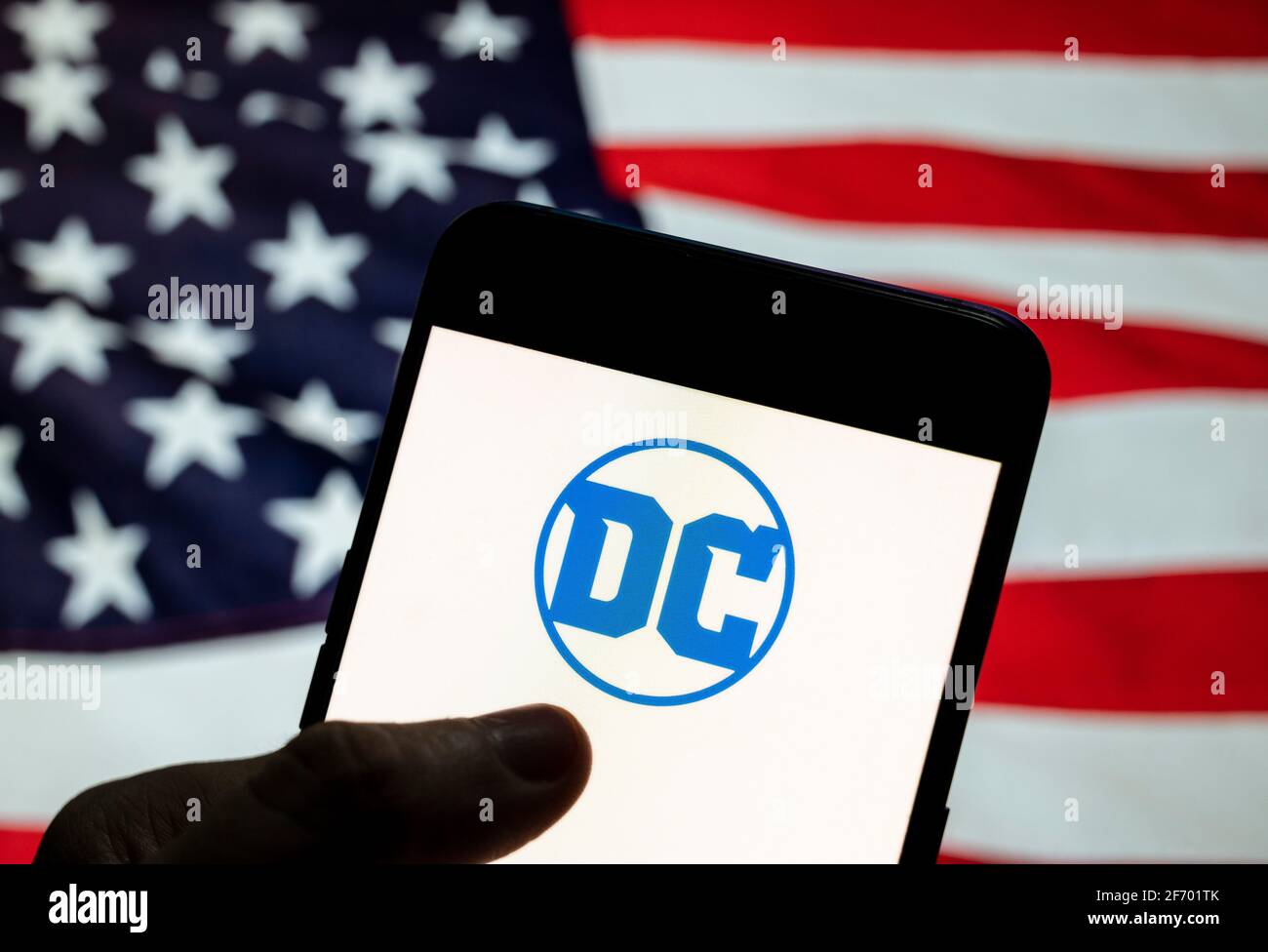 China. März 2021. Auf dieser Fototafel ist das Logo des amerikanischen Comicverlags DC Comics zu sehen, das auf einem Smartphone mit einer Flagge der Vereinigten Staaten im Hintergrund zu sehen ist. Quelle: Chukrut Budrul/SOPA Images/ZUMA Wire/Alamy Live News Stockfoto