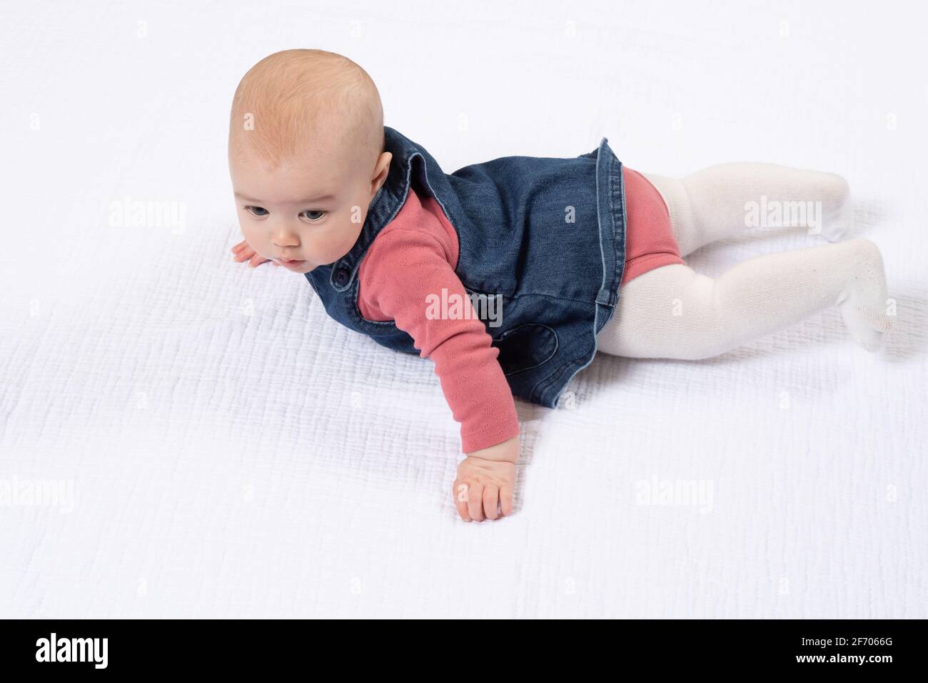 4 Monate altes Baby Mädchen voller Länge auf dem Bauch nach Rollover der Serie 3 von 3 Stockfoto