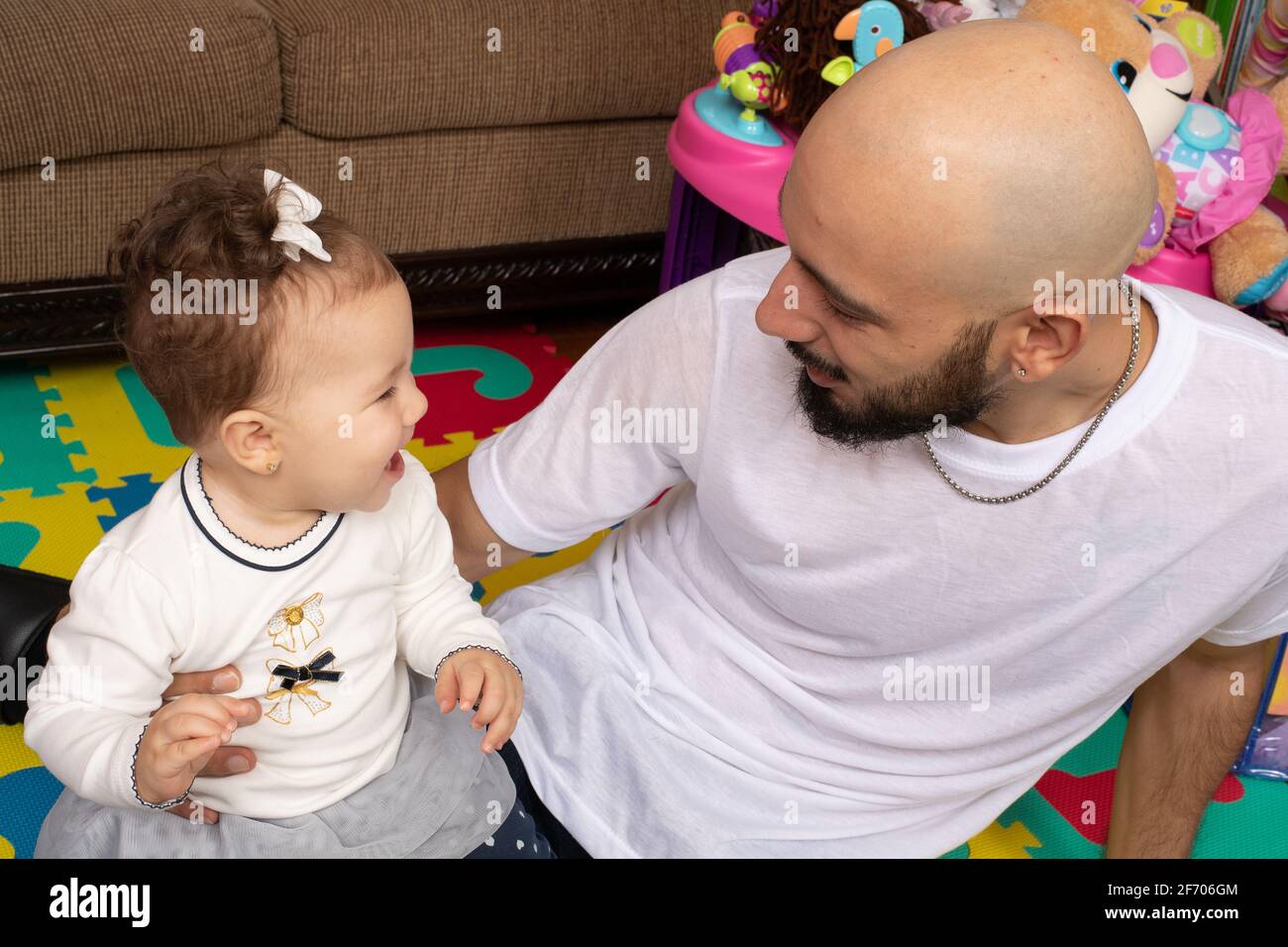 7 Monate altes Mädchen, das mit dem Vater interagiert und lacht Stockfoto