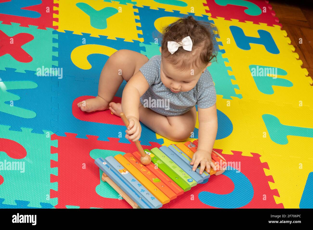 7 Monate altes Baby, das Xylophon mit Holzhammer schlägt Stockfoto