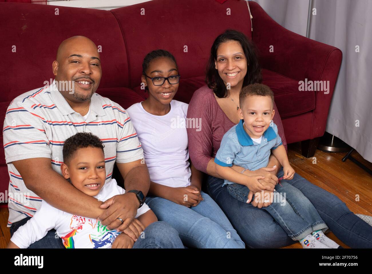 Gemischte Familie zu Hause, Ehepaar Anfang 40, 12-jährige Tochter, 7-jähriger Junge und 3-jähriger Junge Stockfoto