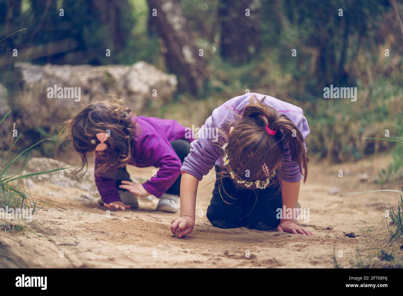 Zwei kleine Mädchen spielen und gehen mit dem Sand. Aktiver Familienurlaub mit Kindern. Spaß im Freien und gesunde Aktivitäten Stockfoto
