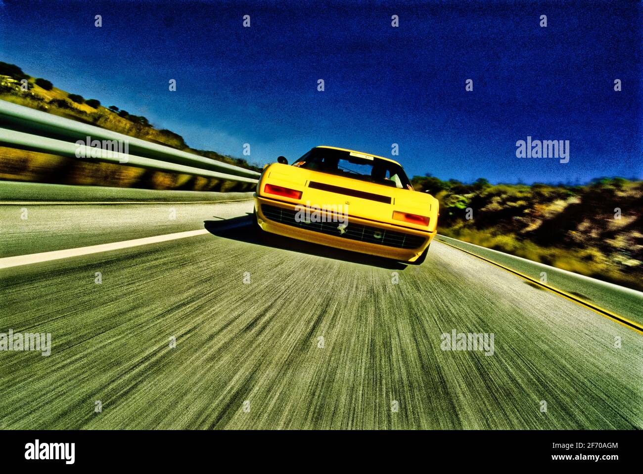 Grafisches Tracking-Bild eines Ferrari-Sportwagens, der mit Geschwindigkeit fährt, in niedriger Winkelansicht (verschwommene Bewegung) Stockfoto