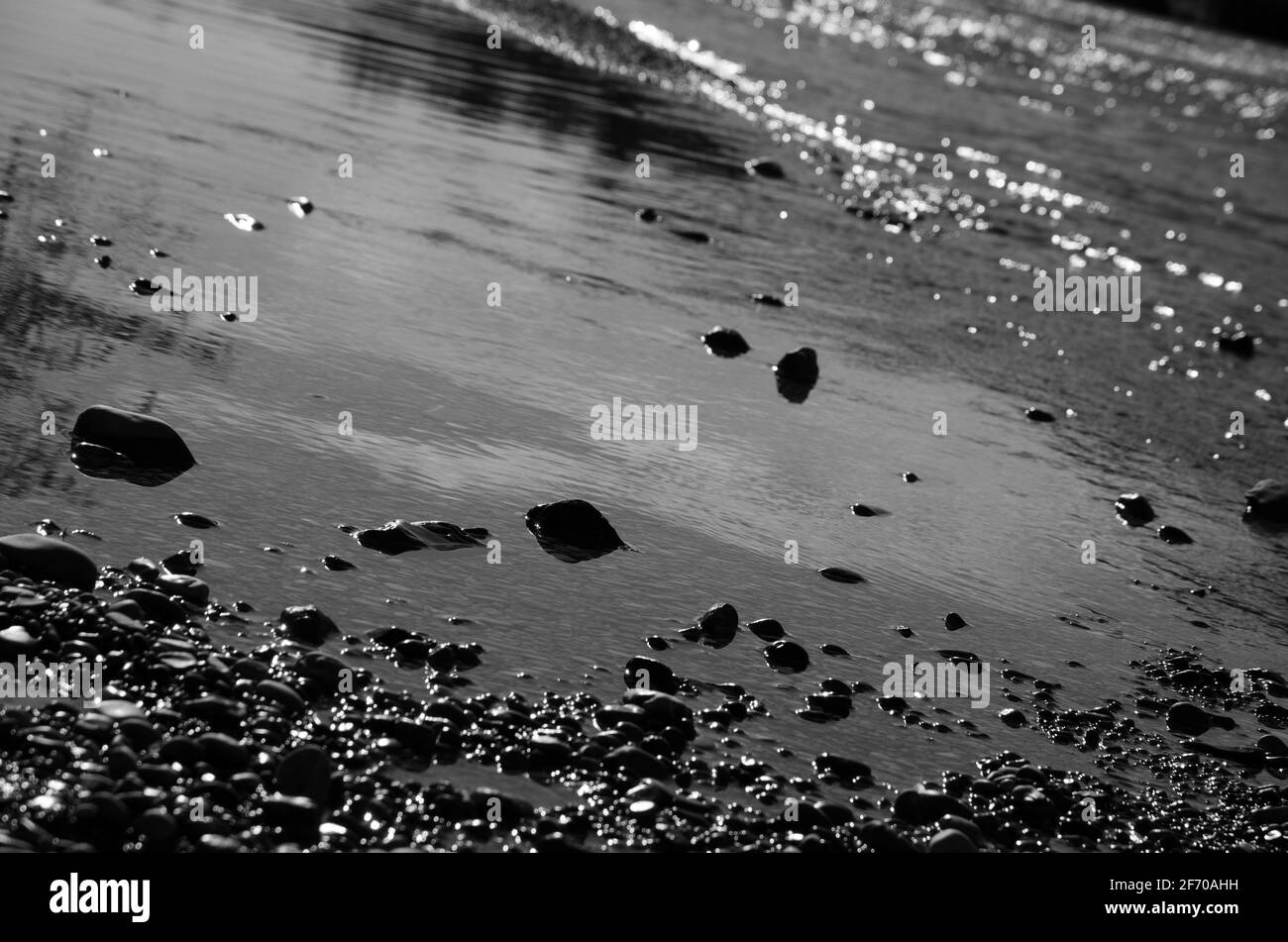 Isars Wasser verschüttet sich über die grünen Moossteine. München, Deutschland. Stockfoto