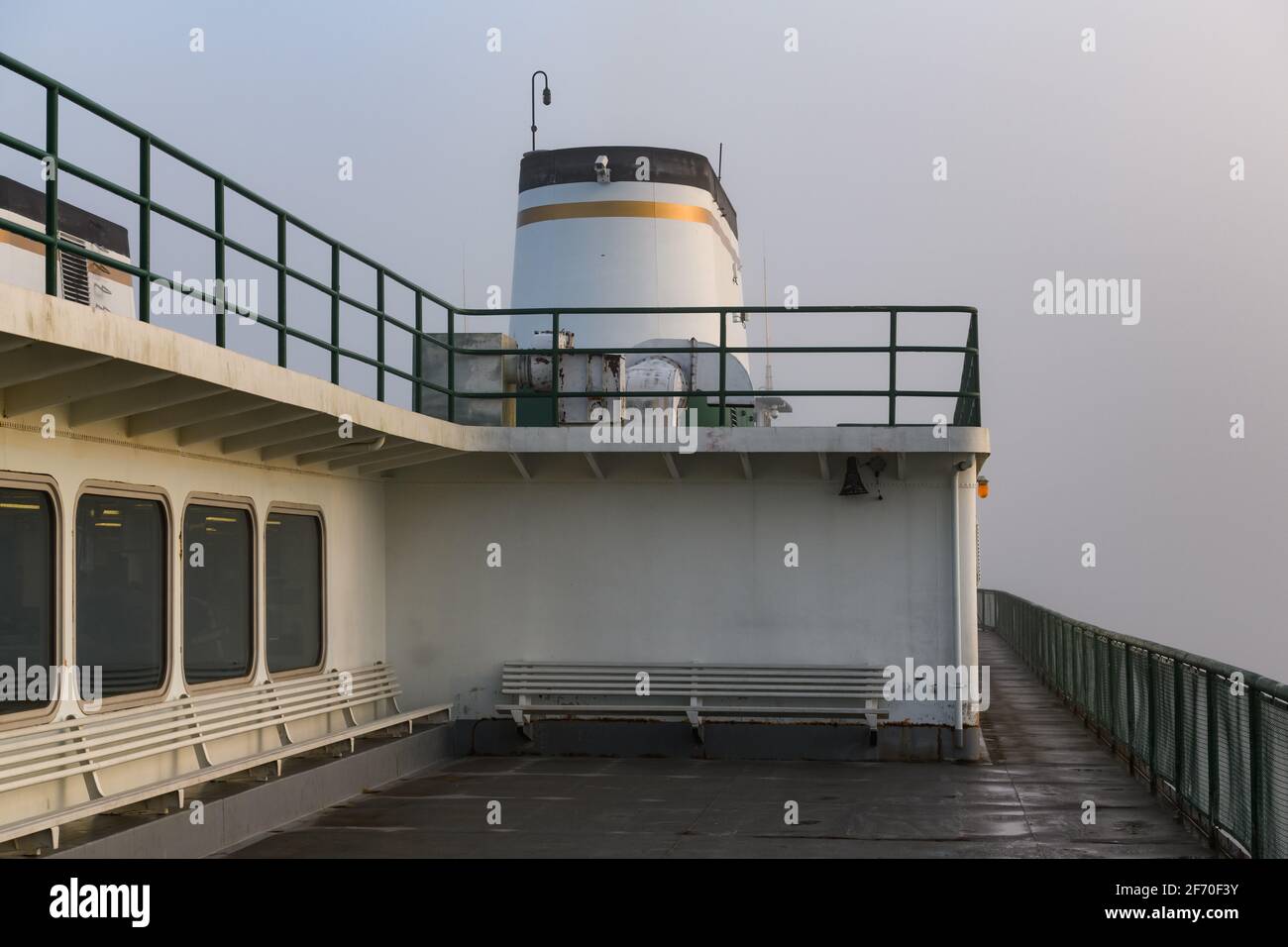 Washington State Ferry Boot mit einem goldgesäumten Trichter Segeln An einem nebligen Morgen mit einem leeren oberen Passagierdeck Stockfoto