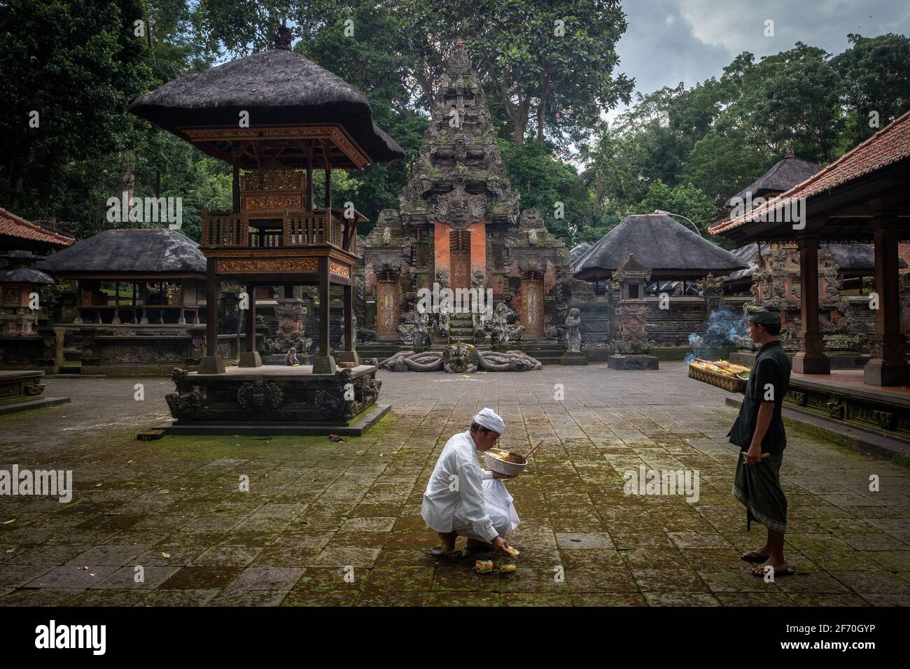 Balinesische Hindus bringen Opfergaben in den alten Dalem Agung Padangtegal Tempel im Sacred Monkey Forest in Ubud, Bali, Indonesien. Stockfoto