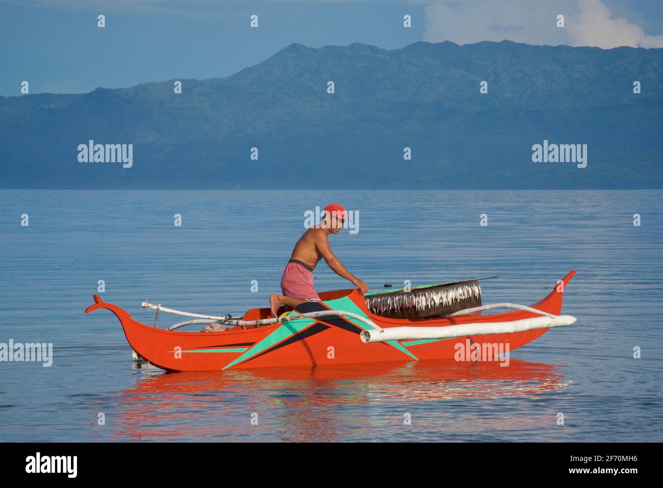 Der philippinische Fischer bereitet sich darauf vor, sein Auslegerkanu zu nehmen, um in der Visayan-See vor Moalboal, Cebu Island, Philippinen, zu fischen. Stockfoto