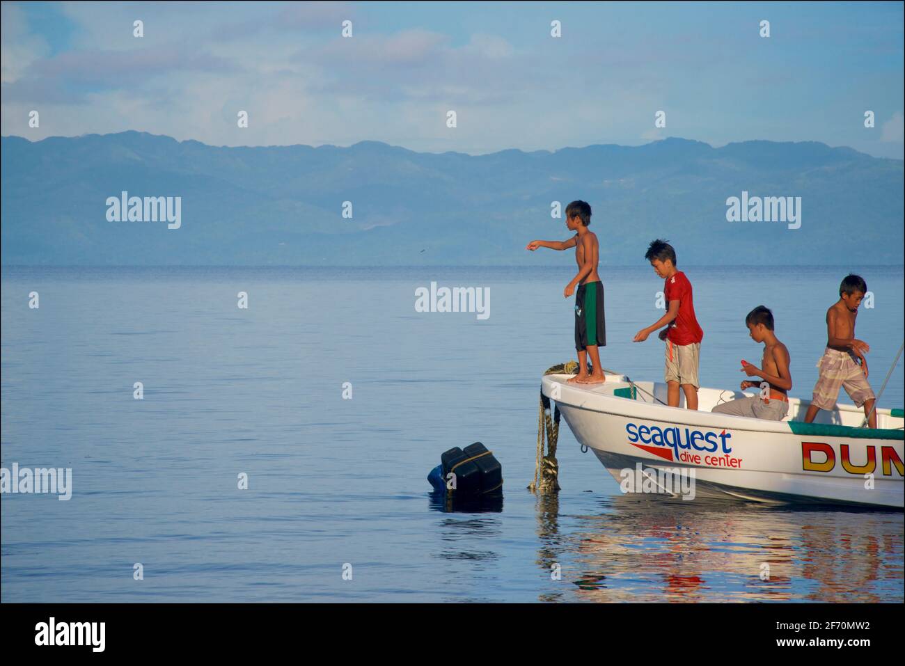 Philippinische Kinder fischen mit einer Schnur vor einem Boot in der Visayan Sea direkt vor Moalboal, Cebu Island, Philippinen. Negros Island Beyond, Central Visayas Region. Stockfoto