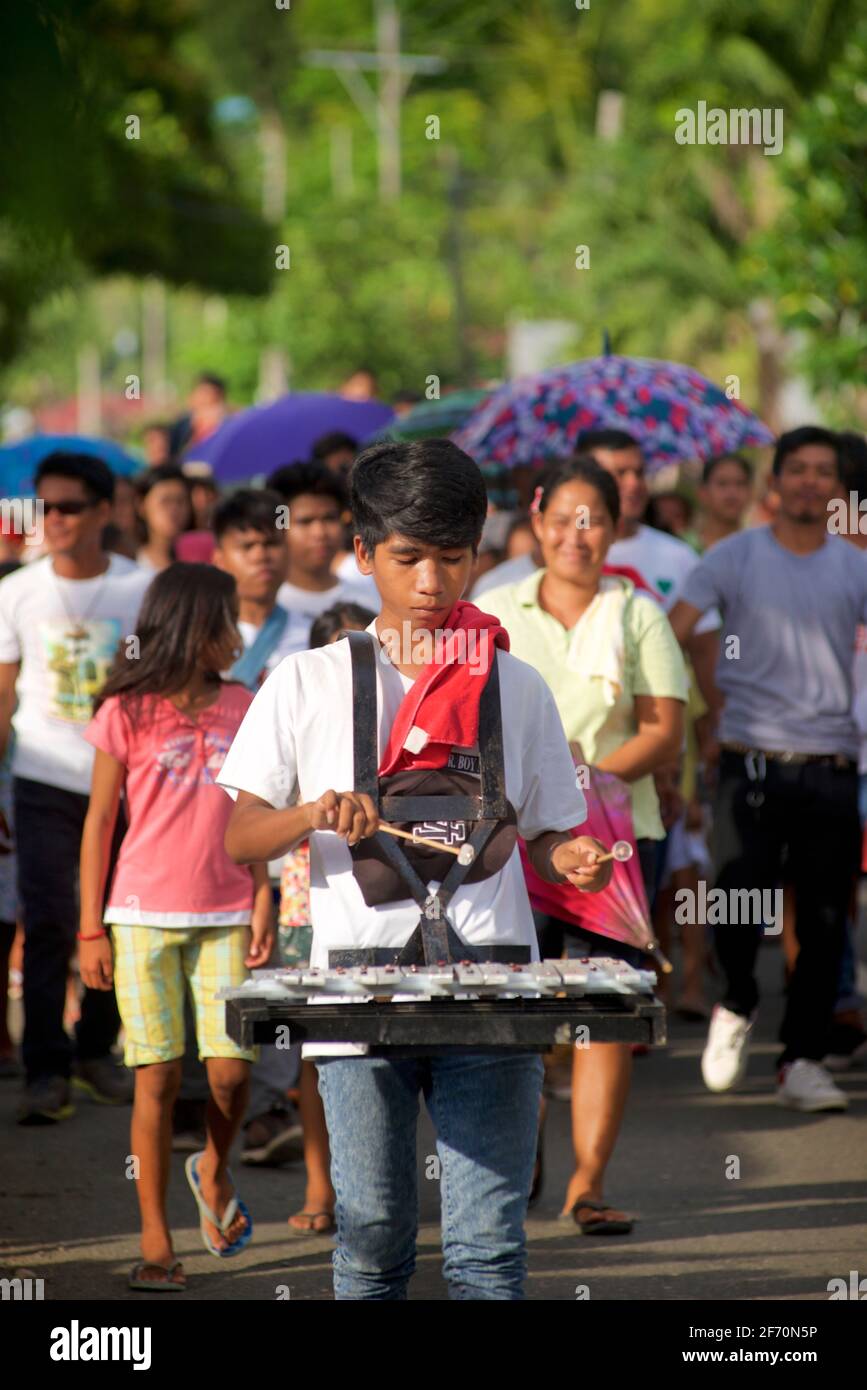 Junger philippinischer Mann spielt das Xylophon in einer Prozession für die Flores de Mayo Feiern, Central Visayas, in der Nähe von Toledo, Cebu, Philippinen Stockfoto