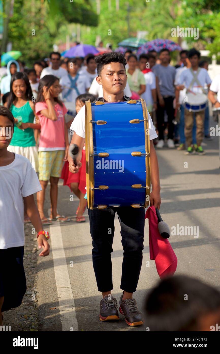 Junger philippinischer Mann, der bei einer Prozession für die Flores de Mayo-Feierlichkeiten im Zentrum von Visayas, in der Nähe von Toledo, Cebu, Philippinen, Schlagzeug spielt Stockfoto