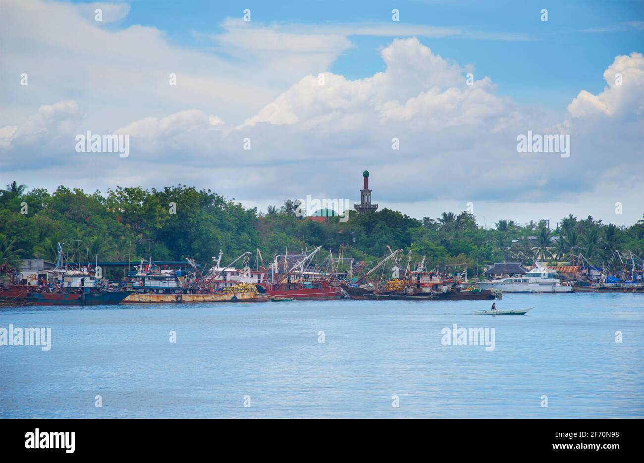 Fischerboote, Punta, Cebu Island. Auf dem Weg zum Hafen von Hagnaya. Philippinen. Lokale Moschee auf der Skyline. Stockfoto