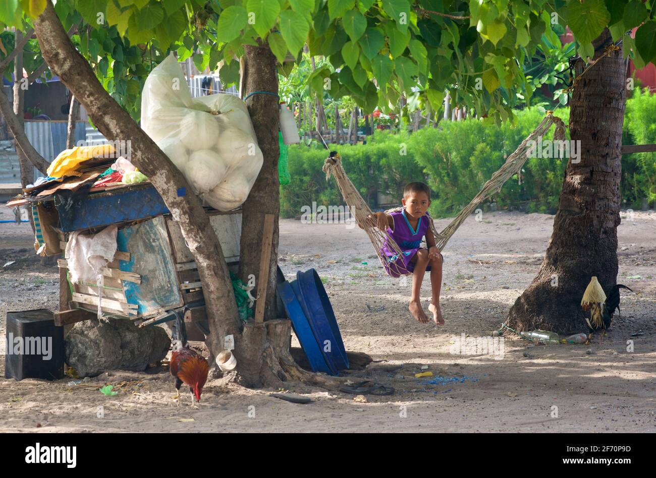 Philippinischer Junge schwingt im warmen Schatten. Malapascua Island, Cebu, Philippinen. Stockfoto