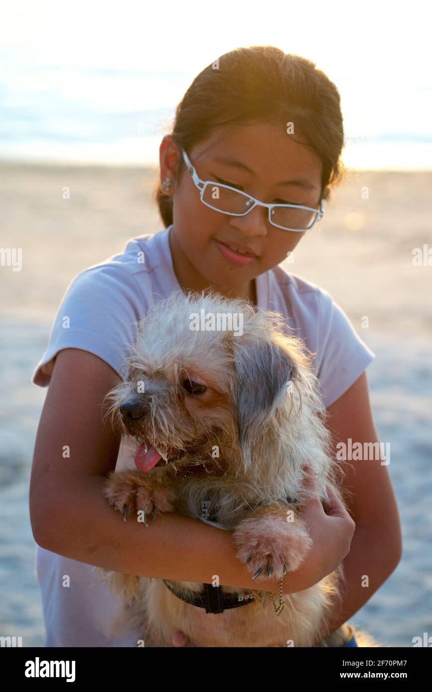 Porträt eines Haustierhundes mit ihrem jungen Besitzer. Malapascua Island, Cebu, Philippinen. Stockfoto