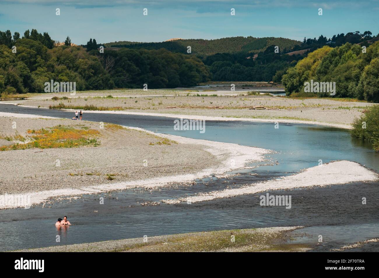 Ein Paar entkommt der Sommerhitze, indem es im kühlen Wasser des Tukituki River in der Stadt Waipukurau, Neuseeland, baden geht Stockfoto