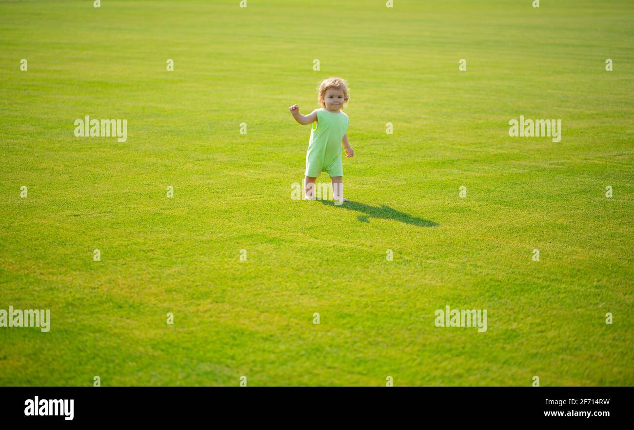 Nette lustige Baby Junge lernen, Schritt zu kriechen, Spaß beim Spielen auf dem Rasen im Garten. Stockfoto