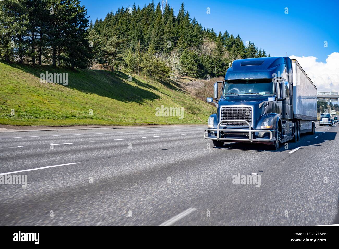 Kommerzielles großes Rig blau industriell grade Langstrecke professionelle semi LKW, der Ladung in einem trockenen Transporter transportiert, fährt weiter Das geteilte mehrzeilige Stockfoto