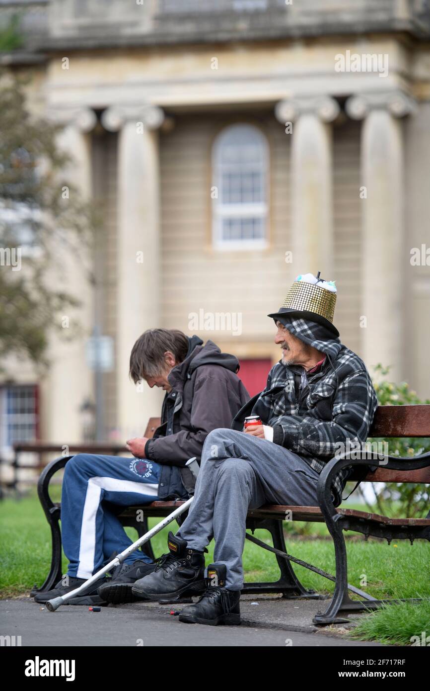 Zwei Männer auf einer Parkbank am Brunswick Square, Bristol, Großbritannien Stockfoto