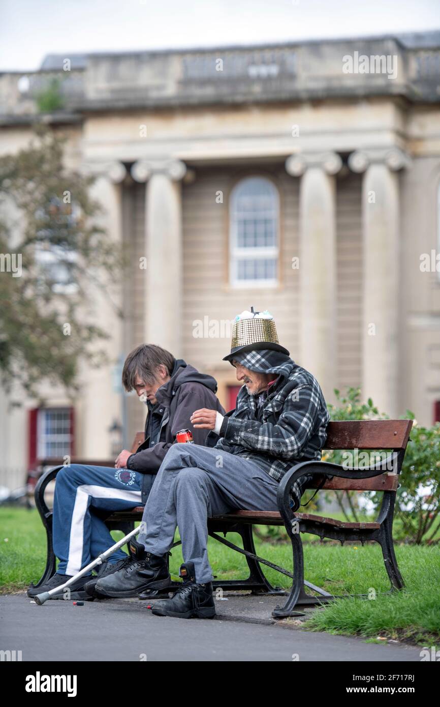 Zwei Männer auf einer Parkbank am Brunswick Square, Bristol, Großbritannien Stockfoto