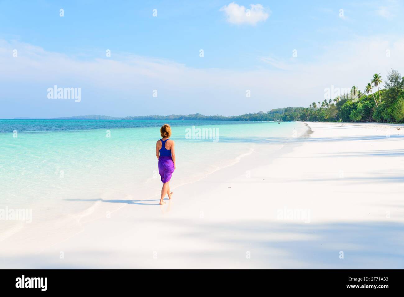 Frau Wandern am tropischen Strand. Ansicht der Rückseite White Sand Beach türkis durchsichtig Wasser Karibik reale Menschen. Indonesien Kei Inseln Molukken trave Stockfoto