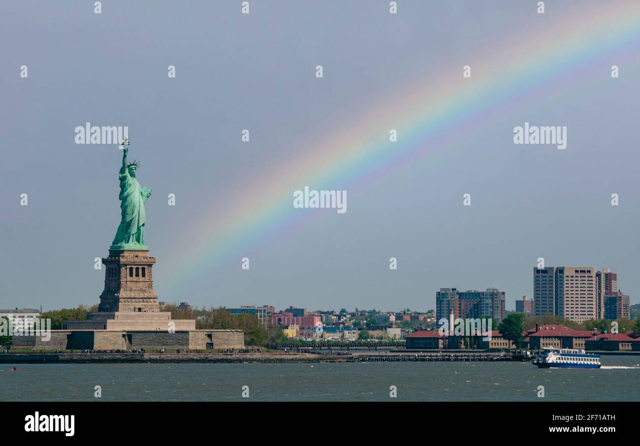 Freiheitsstatue in New york City und ein Regenbogen Am Himmel im Hintergrund Stockfoto