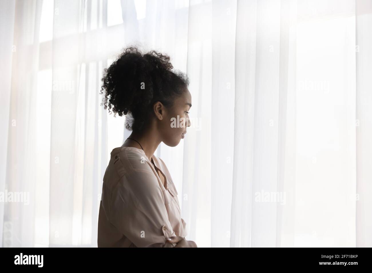 Nachdenkliche afroamerikanische Frau schaut im Ferndenken Stockfoto