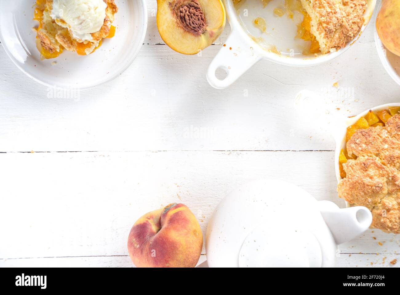 Köstlicher Summer Peach Cobbler, hausgemachter süßer Sommerkuchen mit Pfirsichen und Vanilleeis auf weißem Holzhintergrund Stockfoto