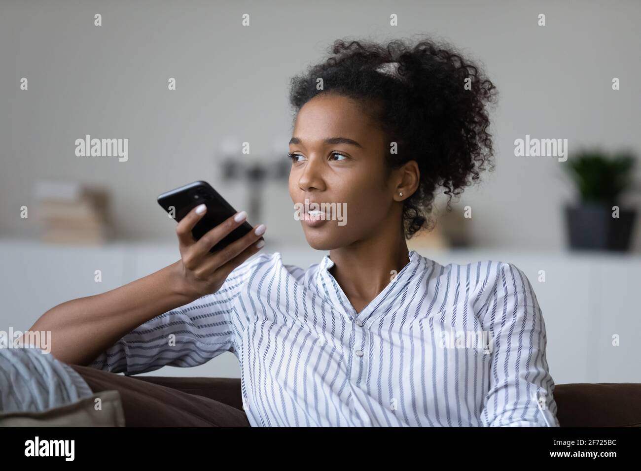 Afroamerikanische Frau spricht auf dem Handy über Lautsprecher Stockfoto