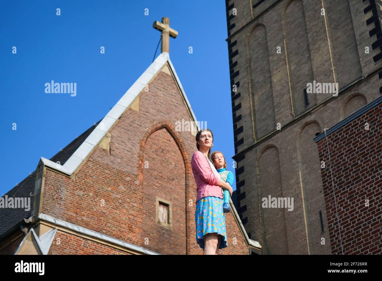 Lebensechte Säulenheilige Skulptur des Künstlers Christoph Pöggeler. St. Lambertus Kirche im Hintergrund. Stockfoto