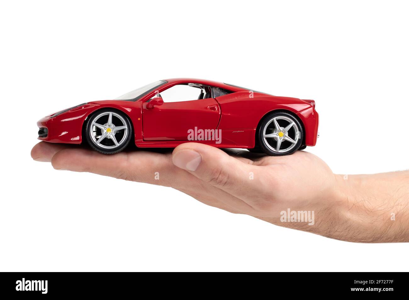 Ukraine. Dnipro. 15. november 2020. Modell eines roten Sportwagens Ferrari in der Hand auf weißem Hintergrund. Stockfoto