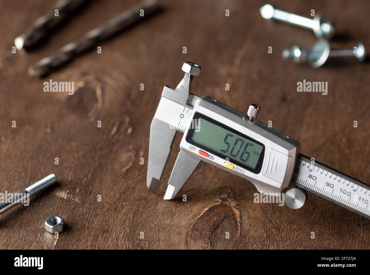 Elektronischer Messschieber auf Holzhintergrund Stockfoto