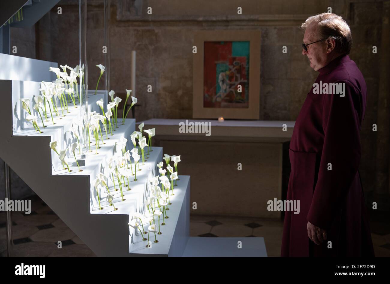 Head verger Howard Waddell betrachtet eine Blumeninstallation mit Calla-Lilien in der Mary Magdalene Chapel in der Chichester Cathedral. Bilddatum: Sonntag, 4. April 2021. Die Struktur spiegelt die Treppe in Graham Sutherlands Gemälde „Noli me Tangere“, das sich ebenfalls in der Kapelle befindet, wider und wurde zum Ende der Karwoche geschaffen. Die Installation wird eine Gelegenheit sein, den Menschen zu helfen, sich an die von der Coronavirus-Pandemie Betroffenen zu erinnern. Stockfoto