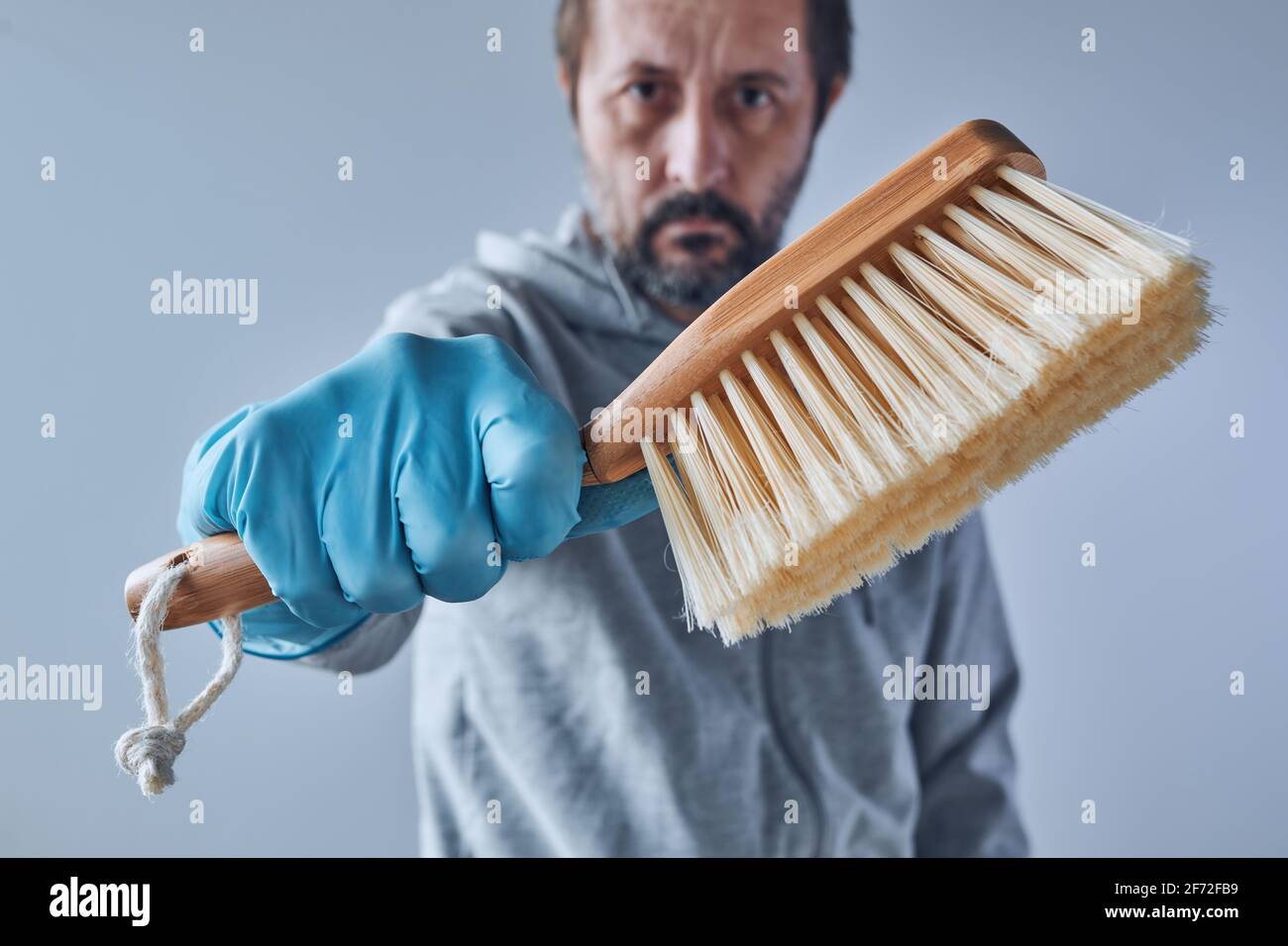 Bereit für die Hausreinigung, Mann mit Bürstenreinigungsausrüstung Stockfoto