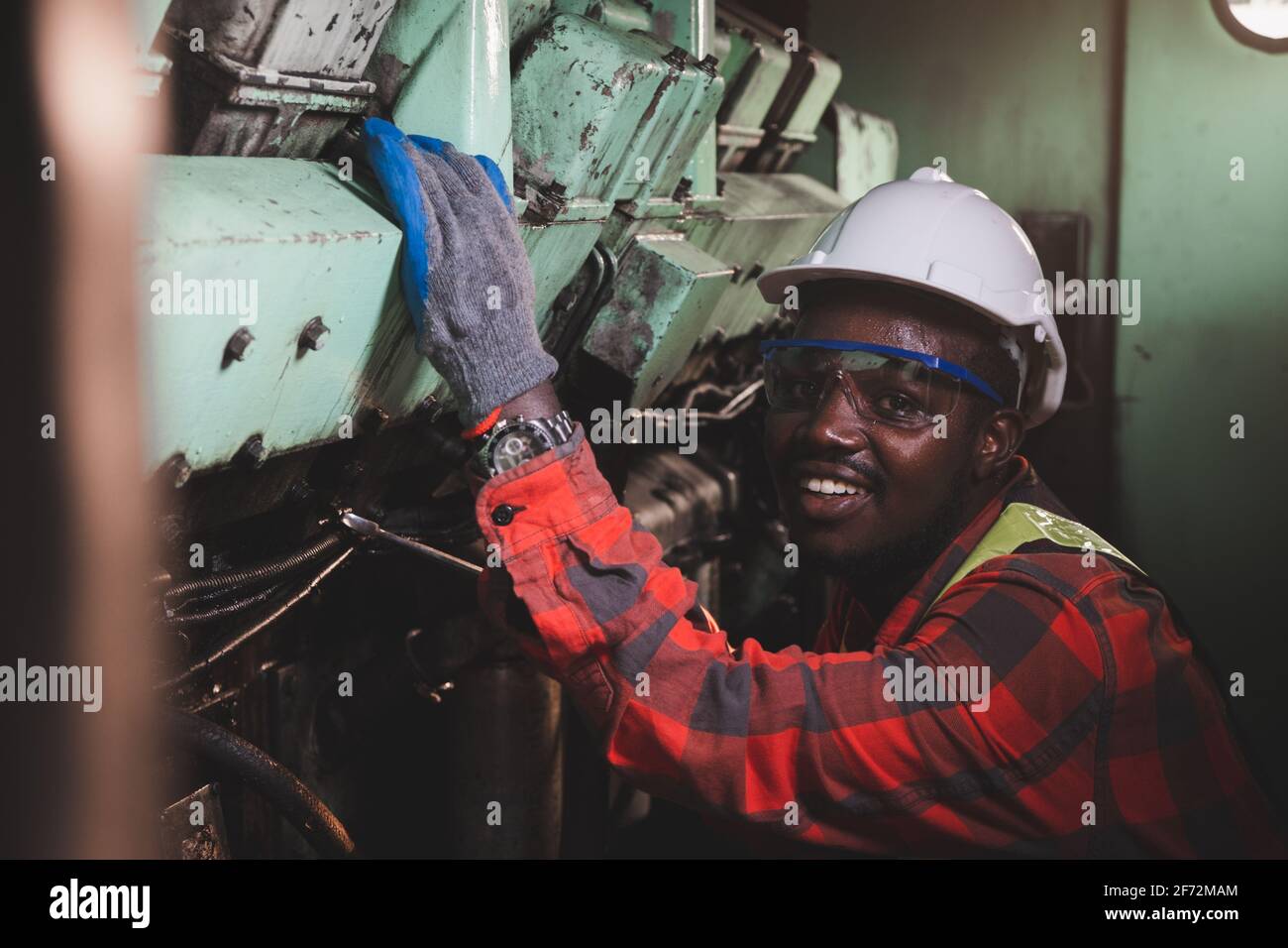 Afrikanische Engineering Engine Machine Controller Überprüfung, arbeiten und sprechen über Funkkommunikation, um Arbeiter in der Industrie zu sagen Stockfoto