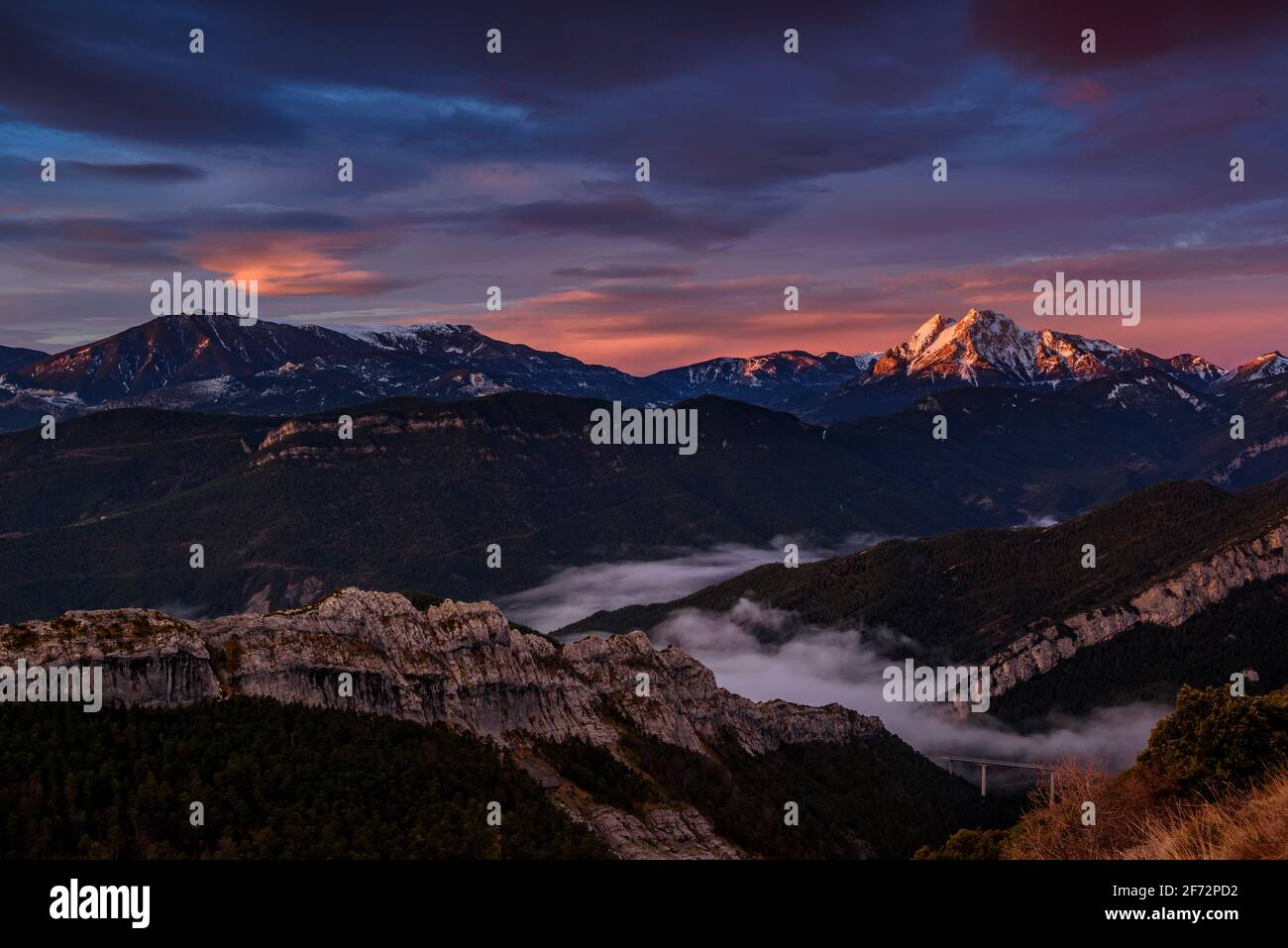 Die Region Pedraforca und Alt Berguedà bei einem roten Winteraufgang vom Coll de Pal Aussichtspunkt aus gesehen (Berguedà, Barcelona, Katalonien, Spanien, Pyrenäen) Stockfoto