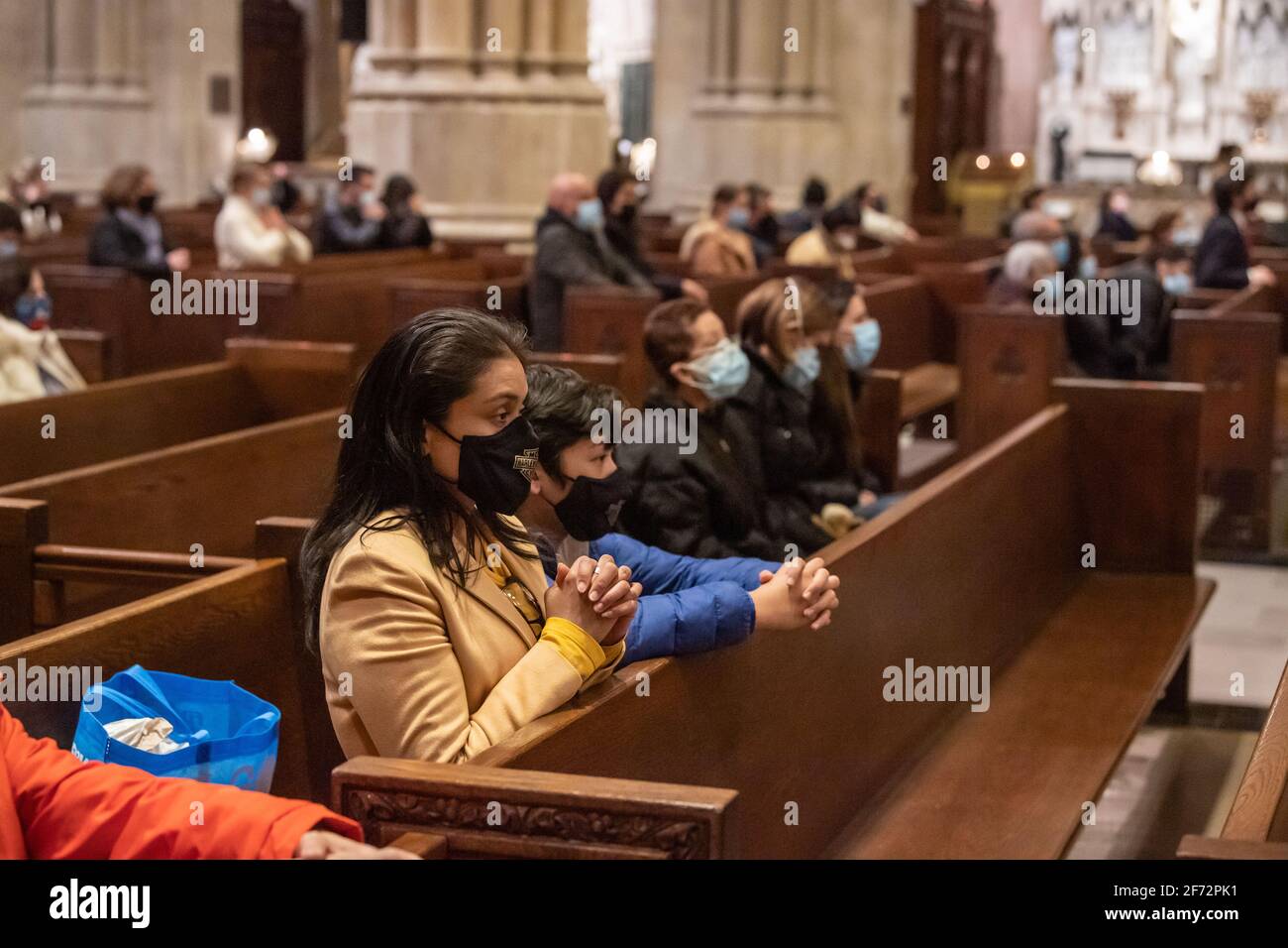 Gläubige beten während der Ostermesse in einer sozial distanzierten St. Patrick's Cathedral in New York City. Der Gottesdienst, der aufgrund der anhaltenden Coronavirus-Pandemie in der Regel einer der größten des Jahres war, wurde von einer kleineren Menschenmenge und Geistlichen besucht. Die Messe wurde live im gesamten Tri-State-Gebiet übertragen. Stockfoto