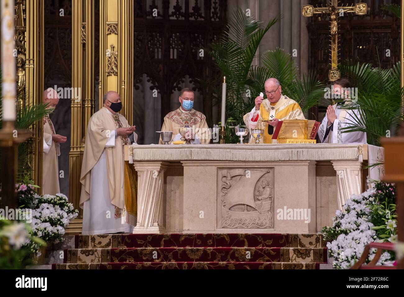 New York, Usa. April 2021. Kardinal Timothy Dolan, Erzbischof von New York, feiert die Eucharistie während der Ostermesse in einer sozial distanzierten Kirche in der St. Patrick's Cathedral in New York City. Aufgrund der anhaltenden Coronavirus-Pandemie wurde in der Regel eine der größten des Jahres von einer kleineren Menschenmenge und Geistlichen besucht. Die Messe wurde live im gesamten Tri-State-Gebiet übertragen. (Foto von Ron Adar/SOPA Images/Sipa USA) Quelle: SIPA USA/Alamy Live News Stockfoto