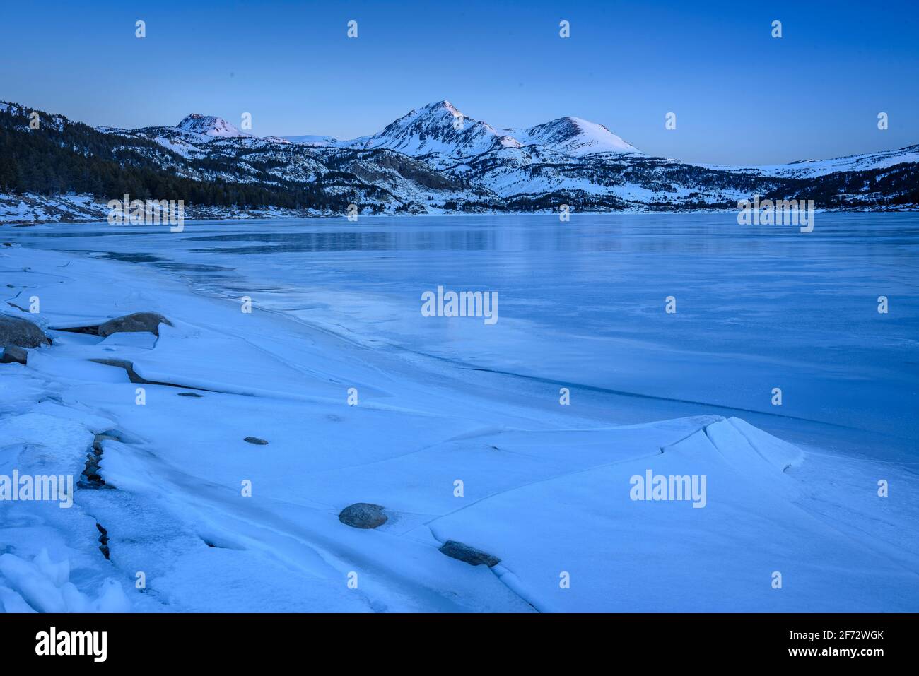 Wintersonnengang am Bouillouses Lake. Im Hintergrund Peric Peaks (Cerdagne, Pyrénées Orientales, Ozzitanie, Frankreich) Stockfoto