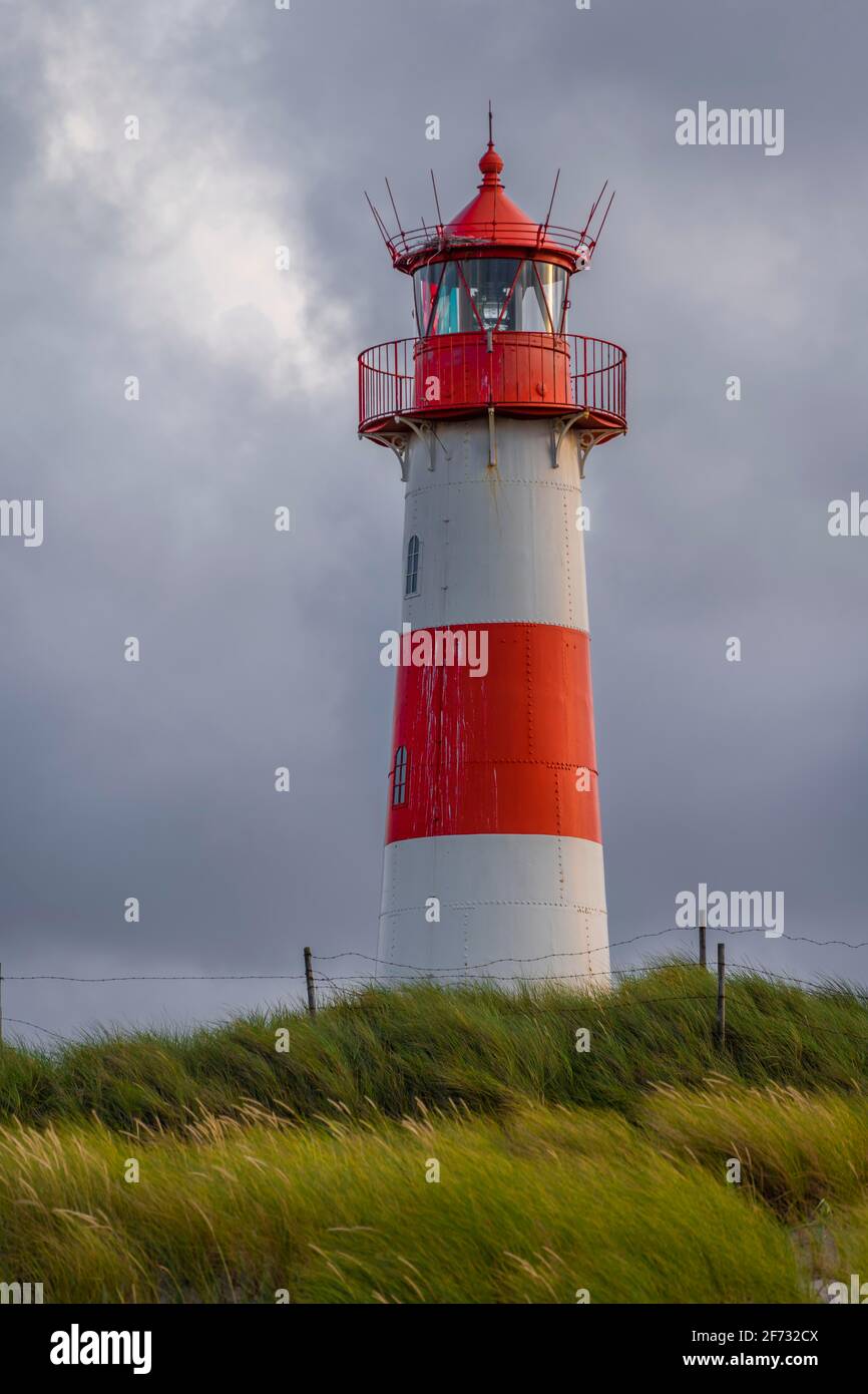 Rot-weißer Leuchtturm List-Ost in den Dünen vor dunklem Himmel, Ellenbogen, Sylt, Nordfriesische Insel, Nordsee, Nordfriesland, Schleswig-Holstein Stockfoto