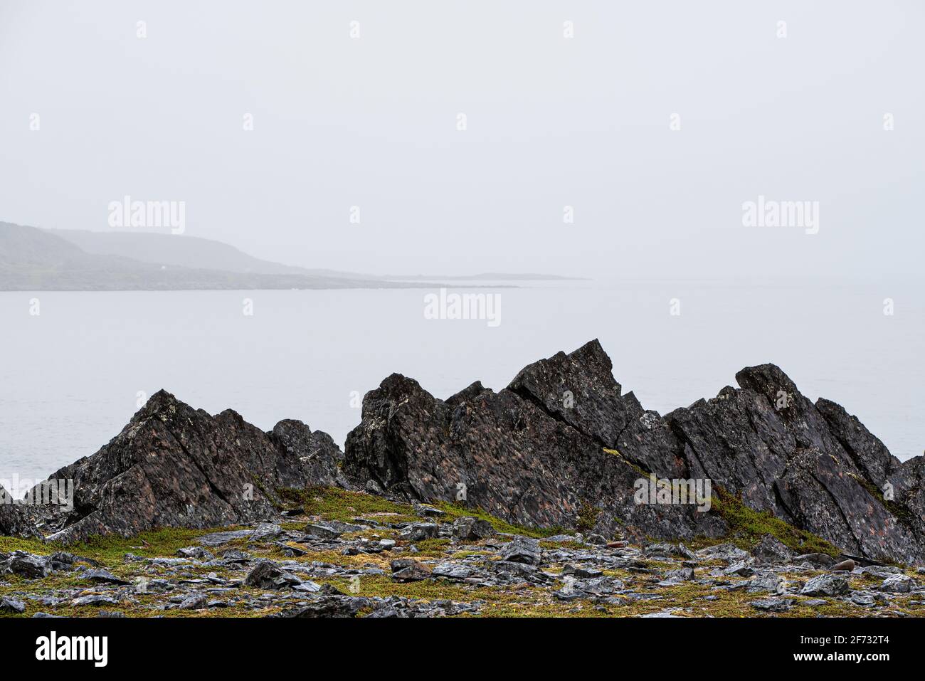 Küstensteine und Schiefergestein, Küste des Arktischen Ozeans auf der Halbinsel Varanger, Finnmark, Norwegen Stockfoto