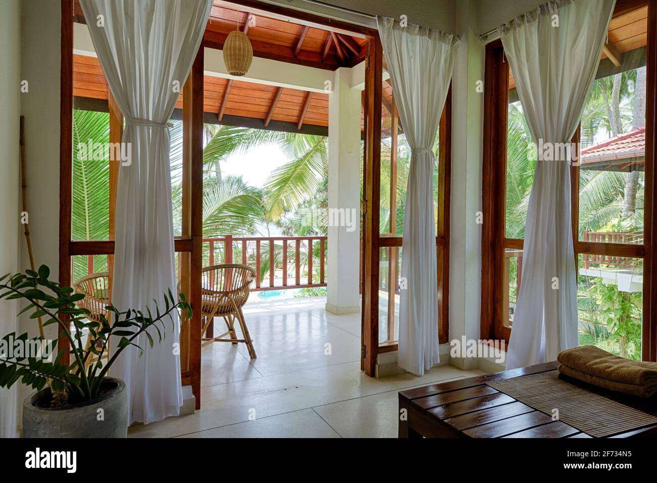 Tangalle, Sri Lanka - Nov 2, 2017: Hotel- oder Wohnhaus im tropischen Garten, Zimmer mit Terrasse, Fenstern und Meerblick. Home Interieur in Indi Stockfoto