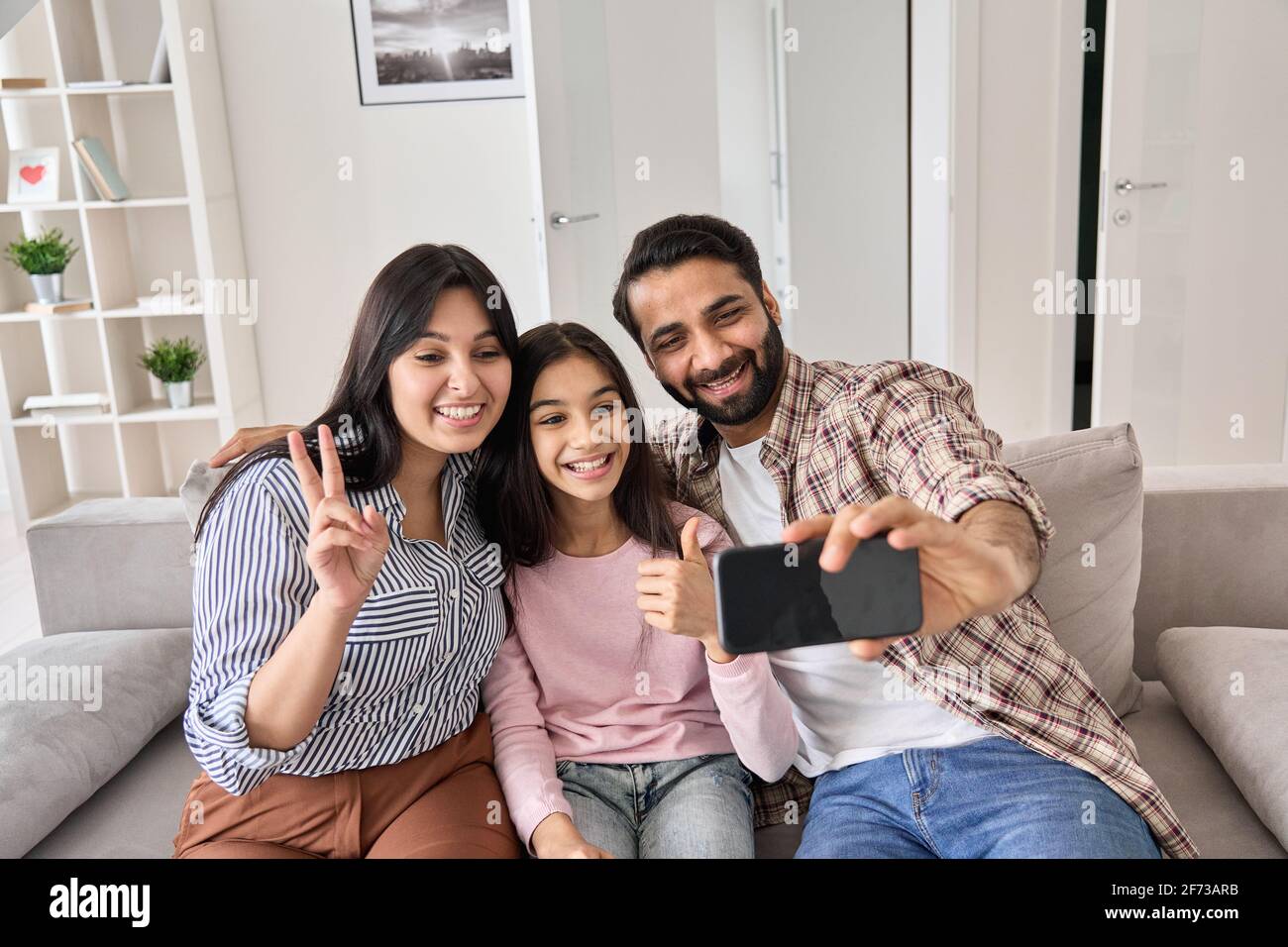 Glücklich lustige indische Familie mit teen Tochter, die Selfie am Telefon zu Hause. Stockfoto