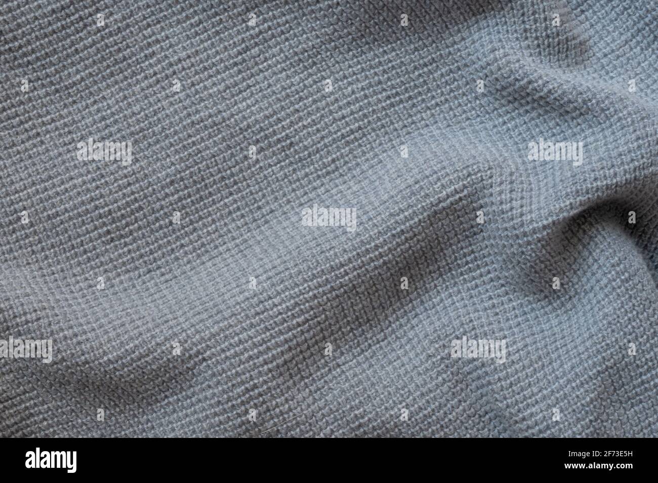 Struktur eines grau-blauen Wollpullovers. Fabric-Hintergrund. Stockfoto