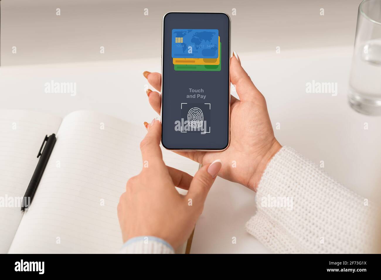 Nicht erkennbare Frau, die online mit Touch ID über das Smartphone bezahlt Stockfoto